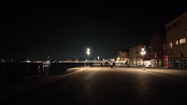 Night POV walking shot along Riva Ca' di Dio with street lamps and city lights in Venice, Italy - Cinematic stabilized