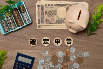 確定申告と現金と豚の貯金箱のイメージ