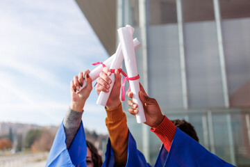 Diverse students proudly holding diplomas, celebrating graduation and academic achievement outdoors