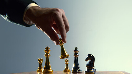 Hand placing gold chess piece among opposing pieces. Concept of business expansion, competitive entry, strategic positioning, growth planning, leadership execution.