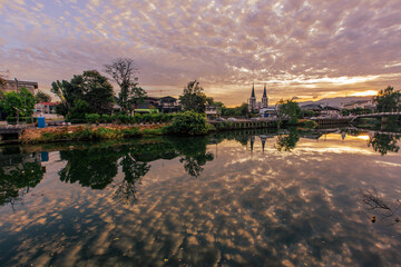 Obraz premium The backdrop of the evening sky along the river, with riverside houses and communities, or tall buildings in the capital city, varies from place to place, but the natural beauty remains unchanged.