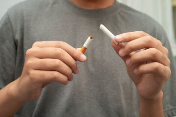 Quit smoking, Asian teenage man breaking destroy cigarette in hand.