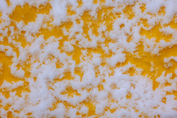 Very fine surface and texture of white fluffy snow pattern in winter, White and cool seamless of snow on yellow wall, Natural wallpaper  Can be used as background for display or montage your products.