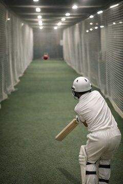 Young Cricketer Practicing in Indoor Facility