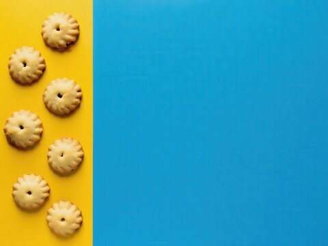 Hamantaschen pastries arranged on a vibrant yellow background. Traditional Jewish cookies symbolize Purim celebrations and family traditions.
