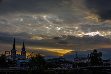 Obraz premium The backdrop of colorful sky lights reflecting off the beautiful river surface at different times of the day, amidst a stunning Christian church in Chanthaburi, Thailand.