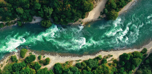 Aerial View of a Raging River: An enthralling overhead perspective showcasing a powerful river as it carves its way through a verdant landscape, illustrating nature's raw and breathtaking force.