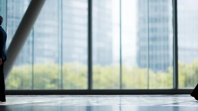 Business professionals shake hands in a modern office surrounded by glass and greenery for collaboration success