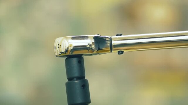 Adjusting torque using dynamometric wrench. Setting tightening force using torque tool. Regulating bolt tension using calibrated wrench. Controlling fastening load using precision torque device