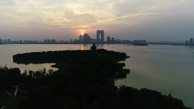 Aerial view of silhouette of pagoda in front of modern skyline of Suzhou, China
