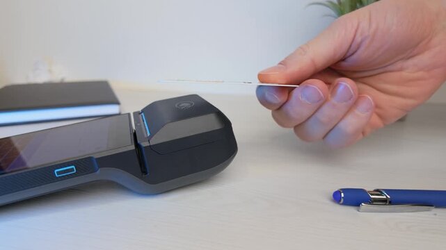 Slow motion card payment on POS terminal positioned on desk during checkout