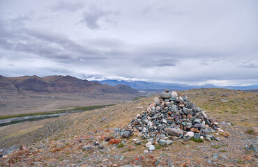 Sacred stone heap pyramid with dramatic view on altai mountains. Altai Republic.