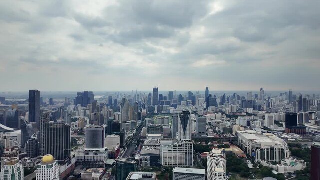 Aerial camera video of dense city skyline under cloudy sky	

