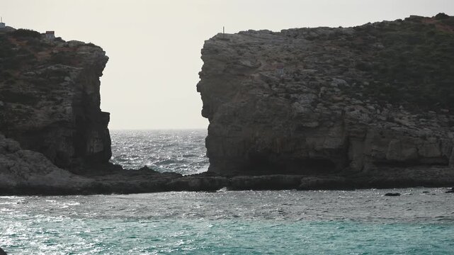 Malta Blue Lagoon landscape. Stunning view of the Blue Lagoon in Comino, Malta, showing the famous turquoise crystal clear waters and the rocky islet of Cominotto under a cloudy sky. 4k video
