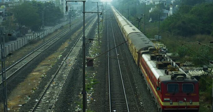 Indian Railway Train Moving on Tracks Through Landscape
