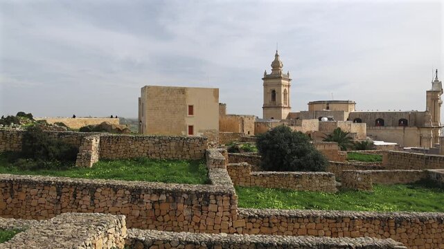 Gozo citadella. Scenic view of the ancient stone fortifications and rooftops within the Cittadella of Victoria, Gozo, showing green grass and traditional limestone architecture. 4k video