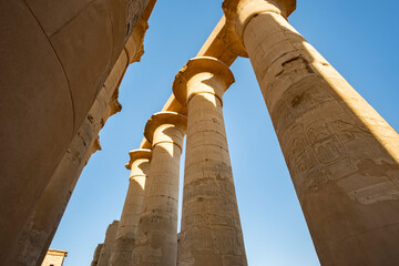 Ancient columns reach towards the sky in Luxor Temple, Egypt during bright daylight