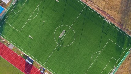Top down drone footage descending over football field, suitable for sports analysis and data visualization concepts - Powered by Adobe