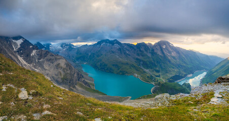 Obraz premium Austria Alps landscape with alpine meadows, forested slopes, and rugged mountain peaks under open sky. High altitude terrain showing natural scenery, geology, outdoor environment, European mountain re