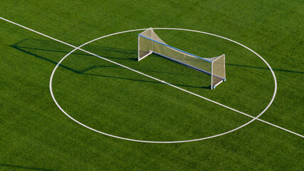 Aerial view of football training goal placed at center circle on artificial turf, clean sports...