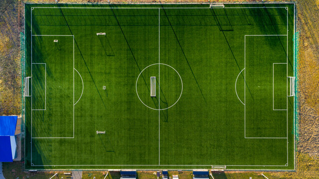 Top down aerial view of football field with artificial turf, ideal for sports analysis and background use