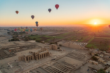 Hot air balloons float above ancient ruins at sunrise in Egypt showcasing beautiful landscapes and rich history of Luxor