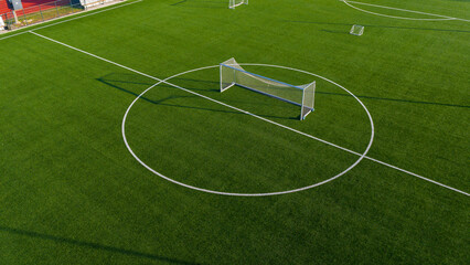 Minimal aerial view of football training goal on artificial turf with clean green background