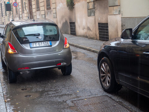 Grey Lancia Ypsilon parked on a wet street in a European city