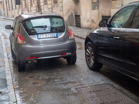 Lancia Ypsilon parked on a wet street during rainfall in Italy