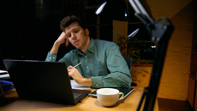 Man mentally exhausted from continuous digital work. Concept of cognitive overload, reduced efficiency, need for breaks, sustainable productivity in technology-driven jobs.
