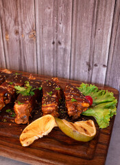 Costillas de cerdo con aderezo y frutos en un fondo de madera