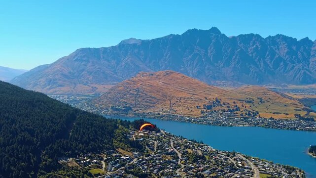 Hang Glider flying over Queenstown South Island New Zealand with Lake Wakatipu and the The Remarkables mountain range in the background