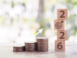 Stacks of coins with wooden blocks forming number 2026 for target financial growth, investment...