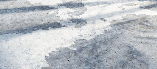 Concrete surface showing ice and water patterns with shadows and ambient light