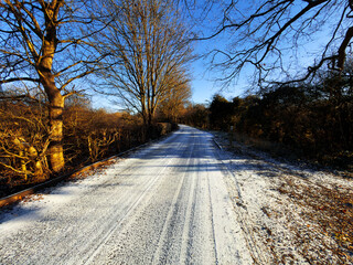 country rural road covered with ice snow and frost