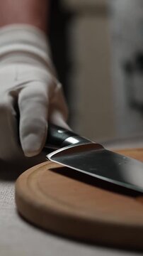 Close-up of a kitchen knife resting on a wooden cutting board in a modern kitchen setting. Concept of cooking, food preparation, culinary tools, and home kitchen lifestyle.