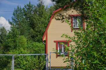 a wooden house among the trees on a summer cottage plot
