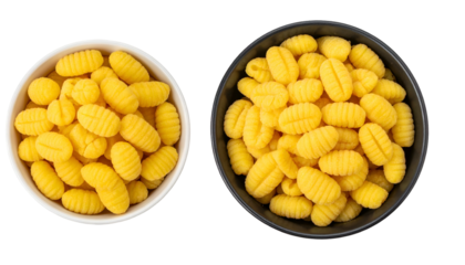 Overhead view of two bowls, one white and one black, filled with yellow gnocchi