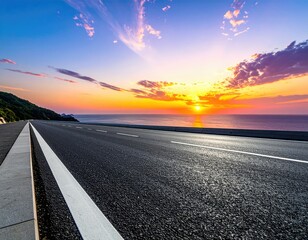 Highway leads toward sunset over ocean, vibrant sky