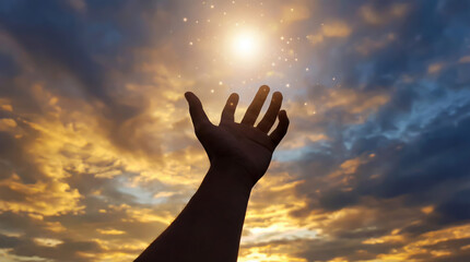 A conceptual image of faith and hope - a man reaching for the light through dramatic clouds at sunset