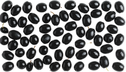 Overhead view of numerous dark, glossy olives scattered on a dark background