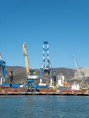 Fototapeta premium August 22 2025 View of Novorossiysk port Russia with cargo ships and cranes on the coastline. Industrial maritime scene on the Black Sea
