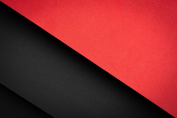 Colorful paper sheets in red and black arranged in a layered fashion on a flat surface at a workspace