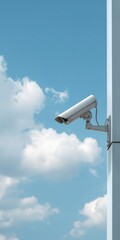 Outdoor security camera on building against cloudy blue sky
