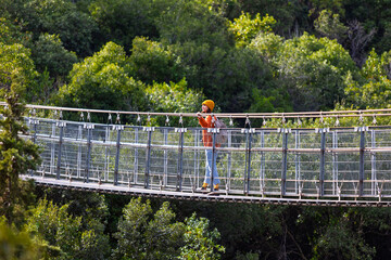 stylish young woman with a backpack travels in sunny weather. Happy female tourist enjoying her...