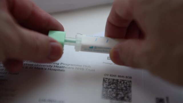 Sealing the collected sample in the Bowel Cancer Screening Programme sample container home test kit.