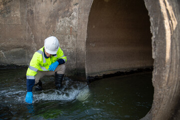 Engineer Inspecting Drainage Culvert and Water Flow for Infrastructure Safety Assessment