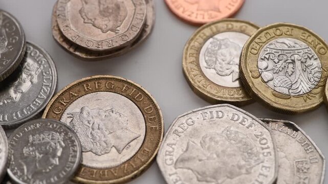 Macro close up of various Sterling Pound coins on white.