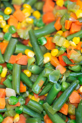 Roasted corn, green beans, carrots and peas, authentic vegetable stir fry full frame backdrop.