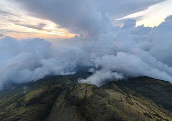 Green mountains with cloudscape cover under morning sky.